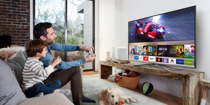 Père et fils qui jouent à un jeu vidéo sur une TV OLED